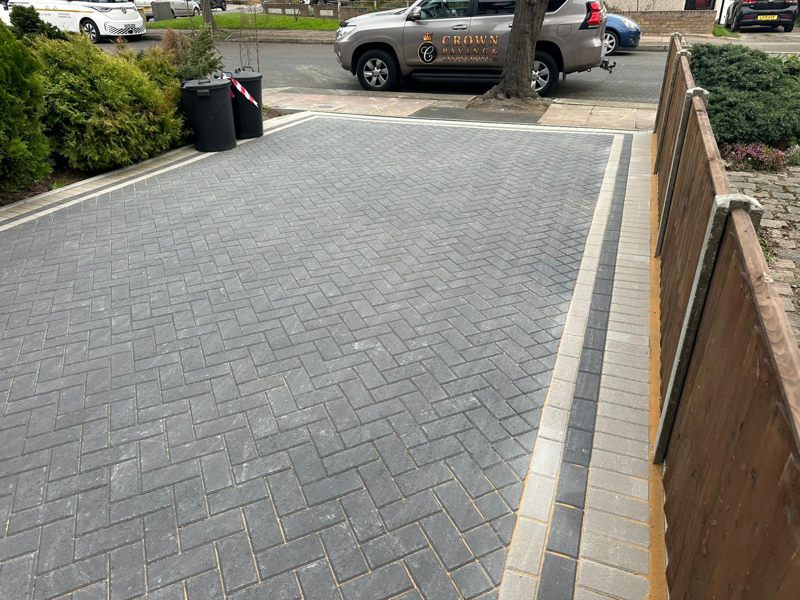Full driveway view with new fencing and drainage